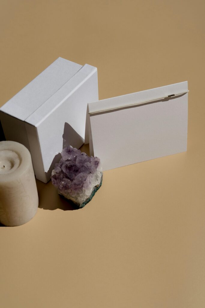Gift card still life with candle, mineral, and blank card on a beige background